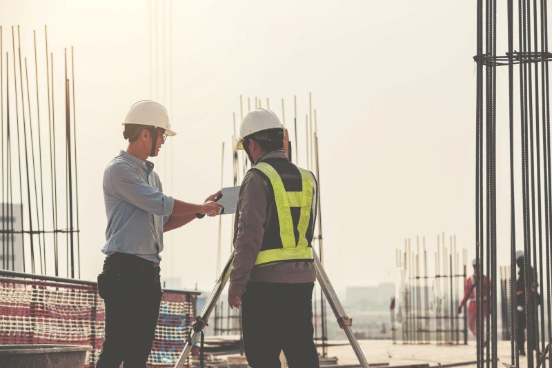 Two construction workers discussing plans at a building site