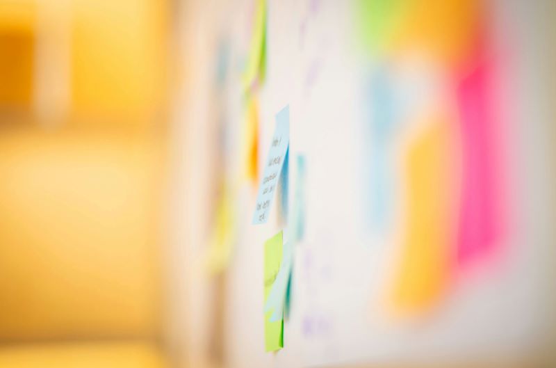 Close up on a board with post-it notes scattered across